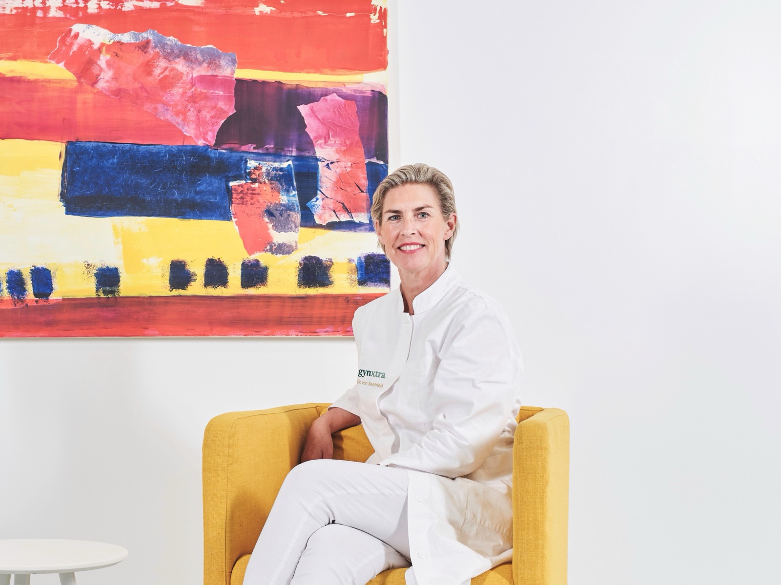 Dr. med. Bettina von Seefried im Sessel vor einem Gemälde